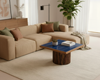 Modern living room with beige sectional sofa, wooden coffee table, and decorative elements.