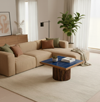 Modern living room with beige sectional sofa, blue coffee table, and decorative elements.