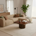 Modern living room with beige sectional sofa, wooden coffee table, and decorative elements.