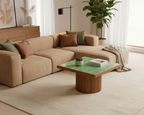 Modern living room with beige sectional sofa, green coffee table, and decorative elements.