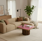Modern living room with beige sectional sofa, pink coffee table, and decorative elements.